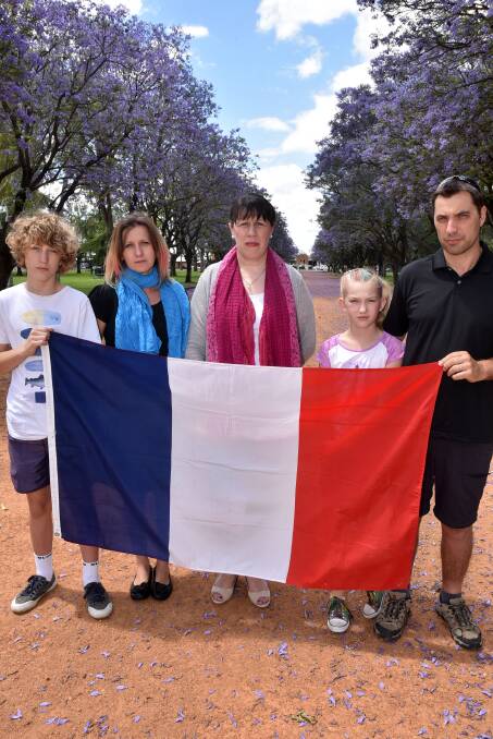 Sarah Arragon (front) and Anthony and Aline Arragon, Patricia Strahorn, and Daniel Arragon show their sadness and solidarity with the people of their French homeland after the deadly terrorist attacks in Paris. Photo: KATHRYN O'SULLIVAN