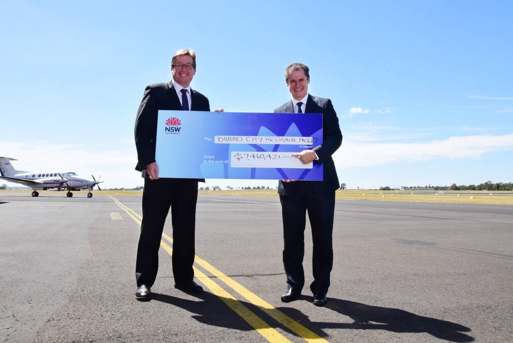 State Member for Dubbo and NSW Deputy Premier Troy Grant presents Dubbo mayor Mathew Dickerson with the $7.4 million for improvements to Dubbo City Regional Airport. 	Photo: BELINDA SOOLE