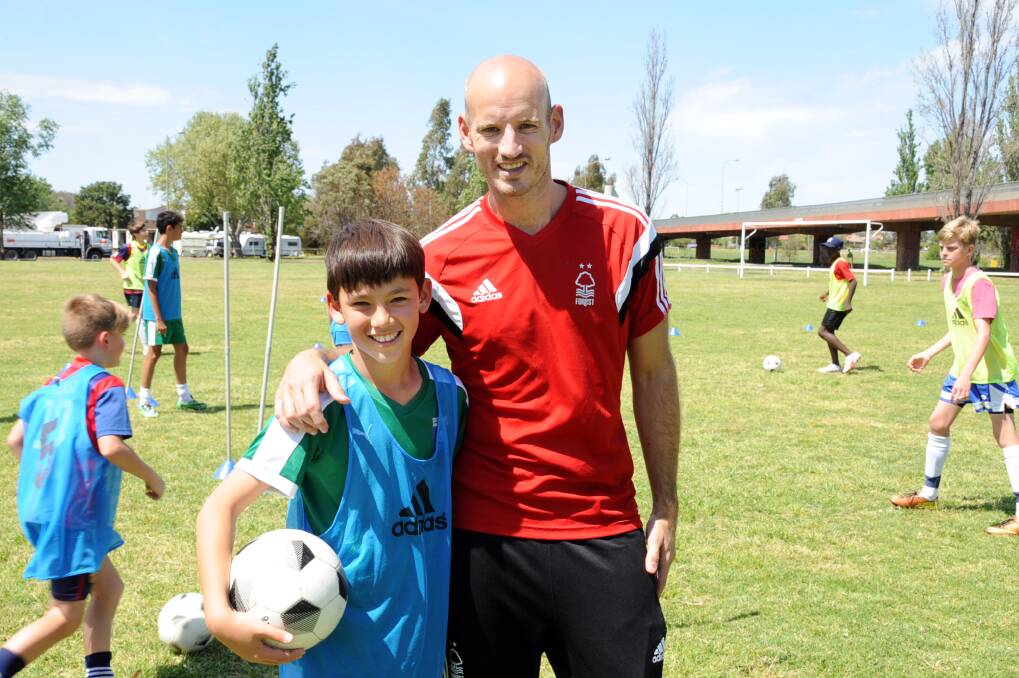 Former EPL player Lawrie Dudfield and Julian Morrison-Zhou take time out from Wednesday's soccer clinic.  
		     Photo: BELINDA SOOLE