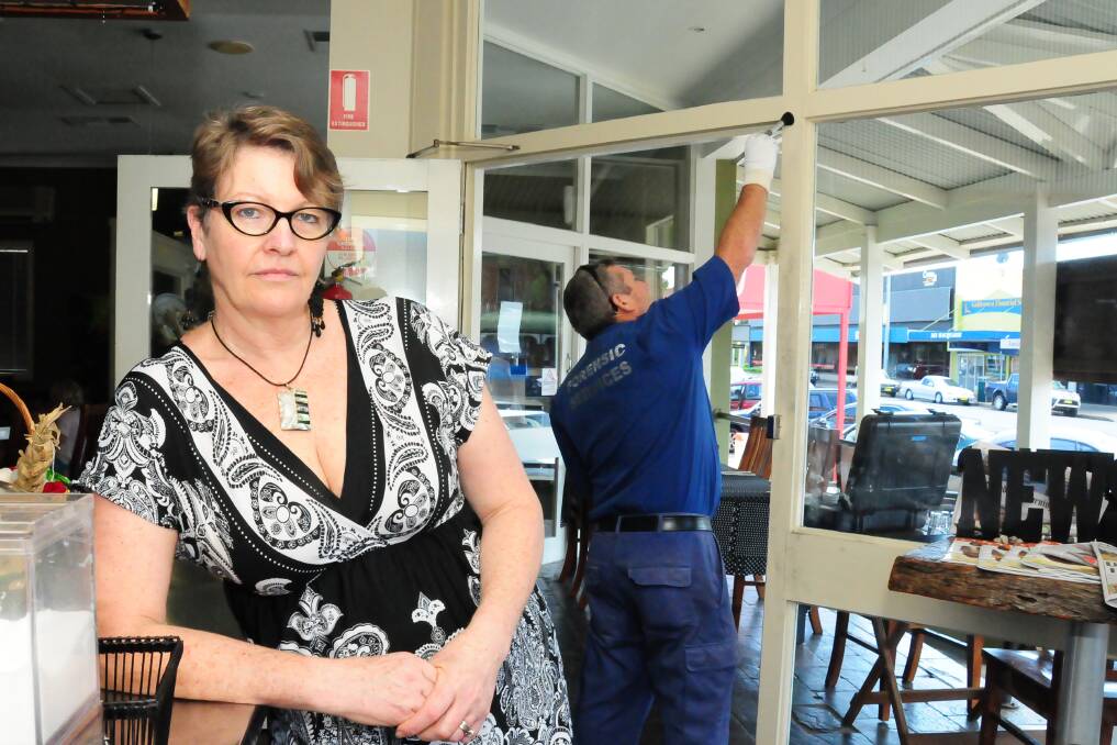 Sticks and Stones owner Gladys Hubbard spent the morning cleaning up after a theft yesterday morning. In the background a forensics officer dusts for fingerprints. Photo: BELINDA SOOLE