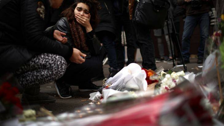 A woman places flowers near the scene of the Bataclan Theatre terrorist attack. Photo: Christopher Furlong
