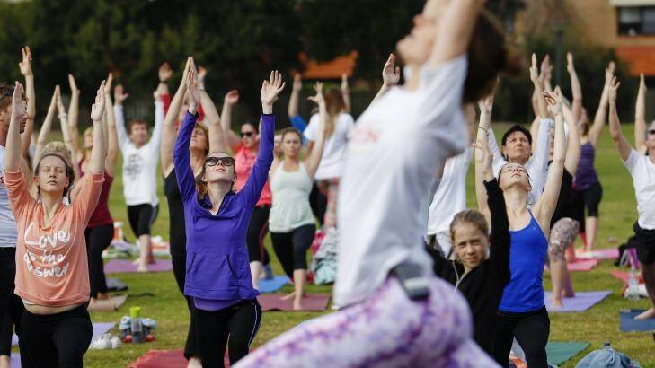 Mass outdoor yoga events are attracting hundreds of people. Photo: Max Mason-Hubers
