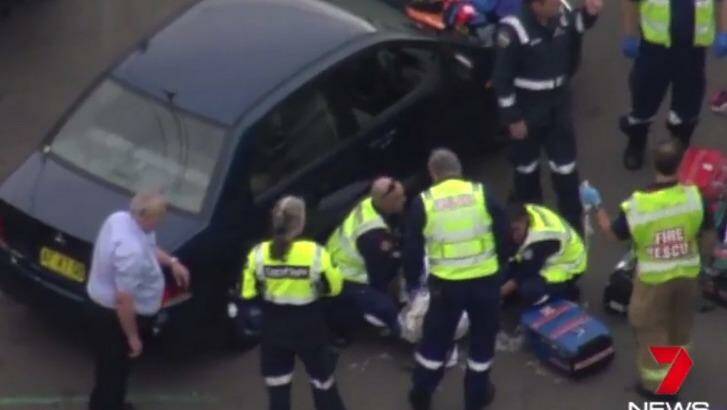 Emergency services tend to the woman, who was knocked down by her husband on Sydney's northern beaches. Photo: Channel Seven
