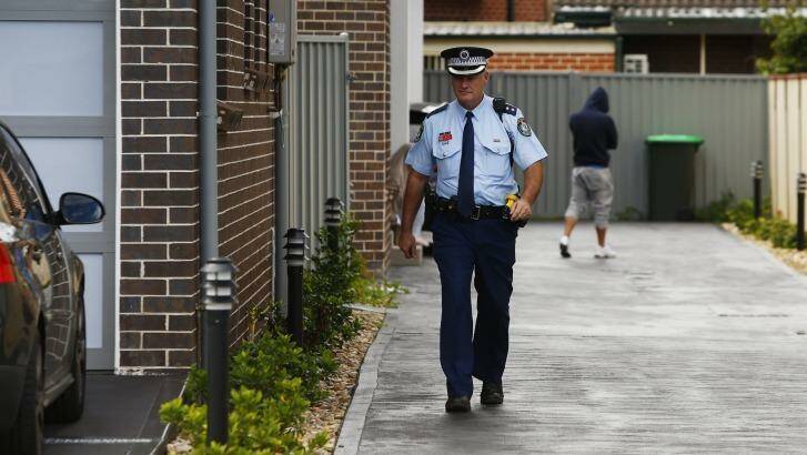 A police officer leaves a Punchbowl property during drug raids. Photo: Daniel Munoz