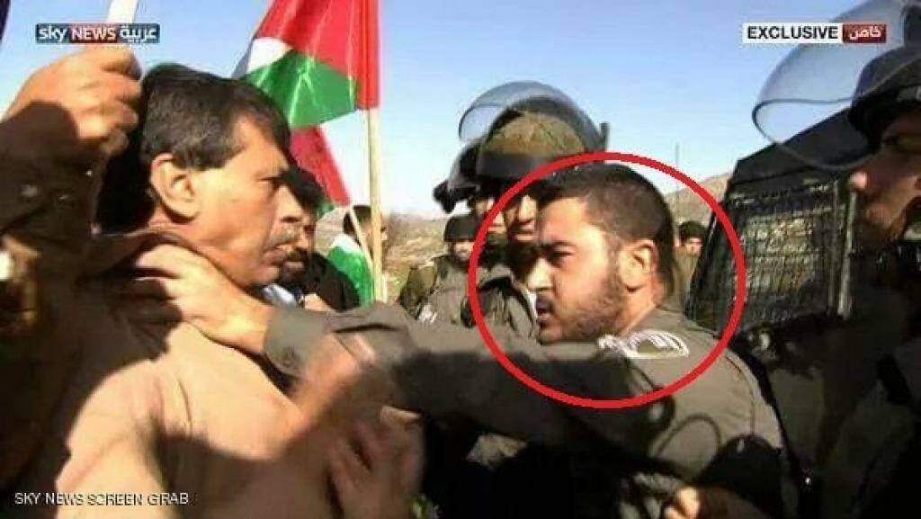 A still of Sky News television coverage showing an Israeli soldier with his hands around the throat of Palestinian government minister Ziad Abu Ein shortly before he collapsed. Photo: Sky News