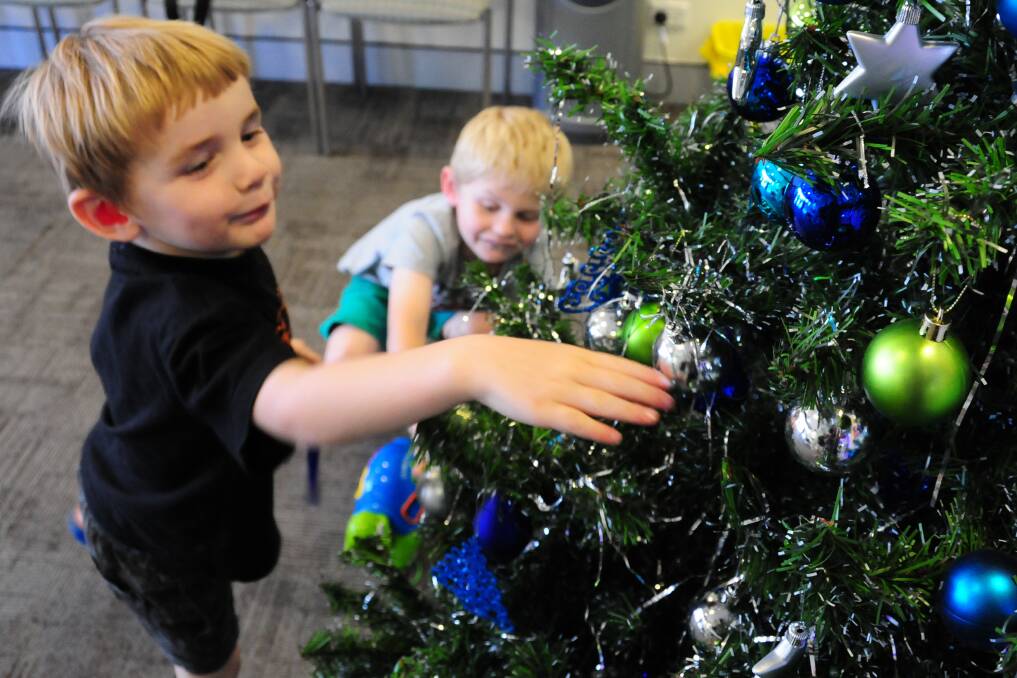 Clayton and Stuart Wheatley check out the Australian Hearing Christmas tree. 					         Photo: GREG KEEN