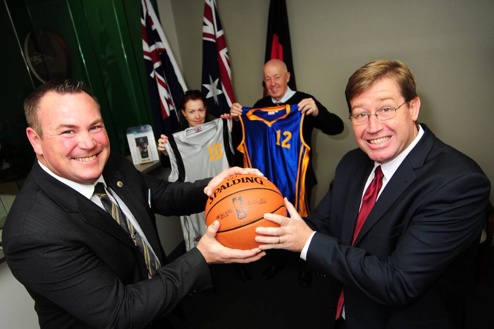 Detective Senior Constable Robert Jackson and Dubbo MP Troy Grant battle for the ball while Detective Senior Constable Sue-Ellen Scott and Dubbo Basketball Association's Peter Hargreaves show off the uniforms for tomorrow's charity basketball match at Dubbo Sports World. 	Photo: BELINDA SOOLE