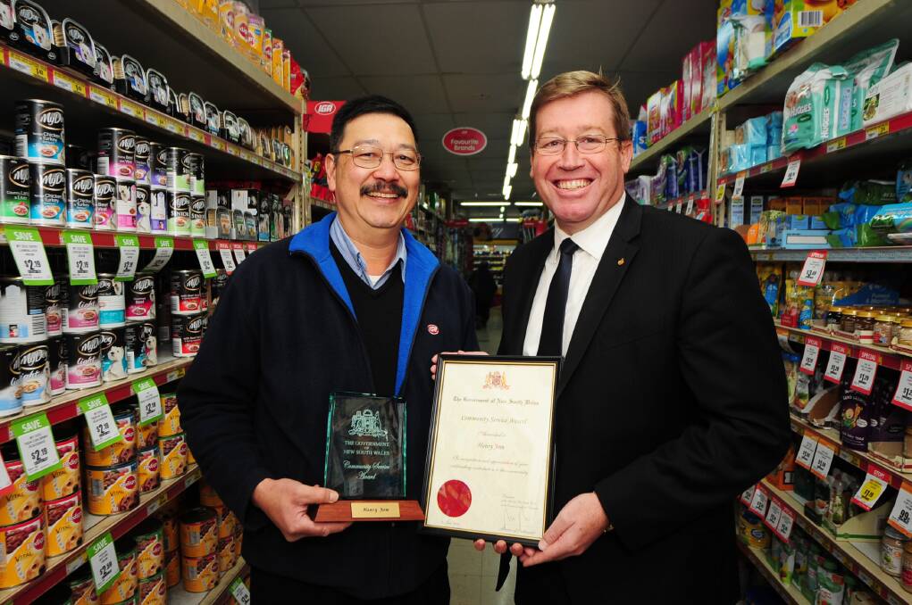 West Dubbo IGA owner operator Henry Jom receives a NSW Government Community Service Award from Dubbo MP Troy Grant. 							  Photo: BELINDA SOOLE