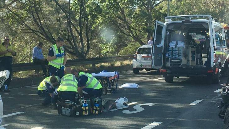 Paramedics treat the injured motorcyclist on the freeway. Photo: Nick Moir