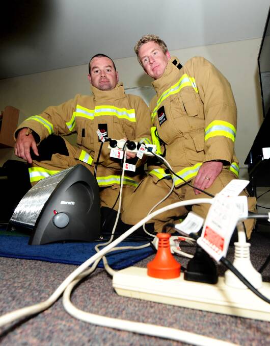 Dubbo firefighters Matt Havercroft and Bernie McTeirnan showing "what not to do" with power boards. 
 
                   Photo: LOUISE DONGES