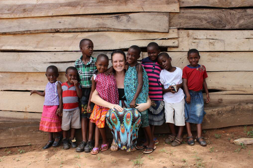 Born and bred in Dubbo, Trishelle Sayuuni (nee Grady) embraces Ugandan children who she is helping through 100% Hope.      Photo: Contributed