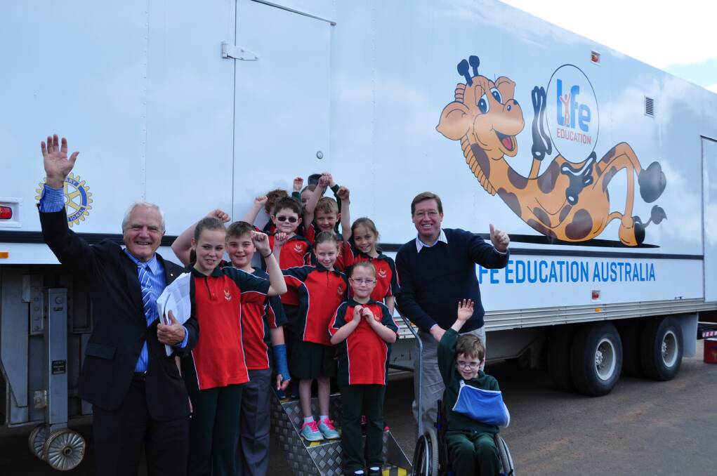 Life Education NSW chairman Alan Cadman and Dubbo State MP Troy Grant with students from Dubbo West Public School in front of the newly refurbished Life Education van. 										   Photo: CONTRIBUTED