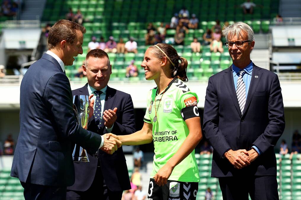 Nicole Begg accepts the W-League trophy at the presentation following Canberra United's 3-1 win over Perth Glory on Sunday.   Photo: GETTY IMAGES