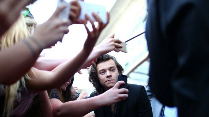 Grinning and bearing it: Harry Styles, of One Direction, is mobbed by smartphone-wielding fans at the ARIAs in Sydney.  Photo: Mark Metcalfe