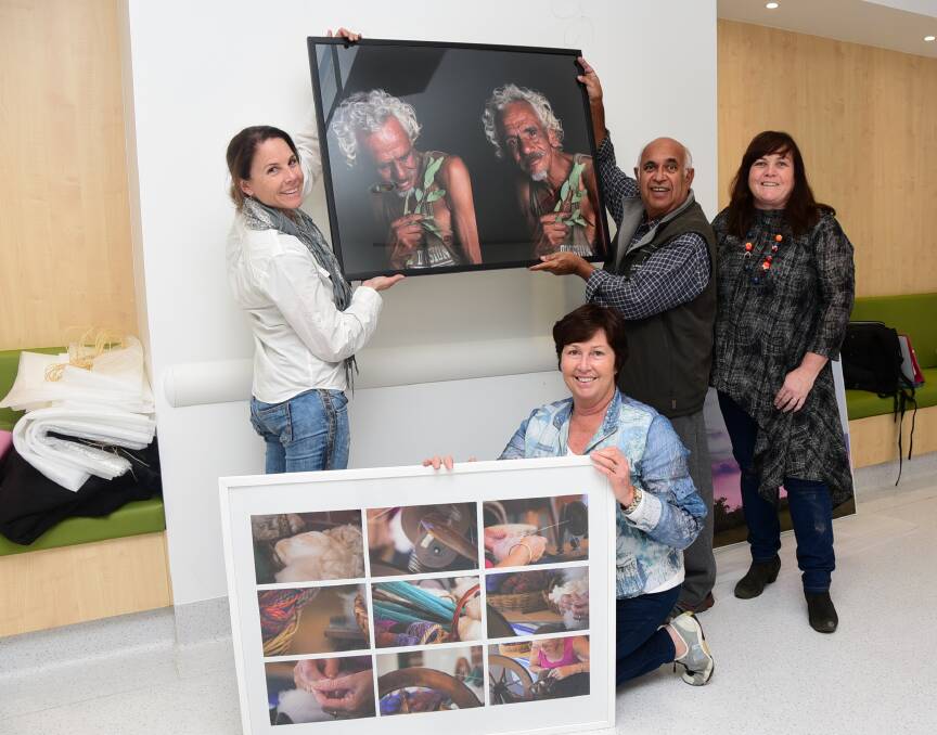 TAFE Western students put up their works in the clinical services building of Dubbo Hospital. They are (from left) Monique Harmer, Judi Unger and Merv Bishop with Base Art Inc member Brigid Palin.    Photo: BELINDA SOOLE
