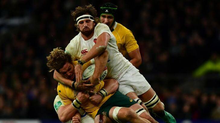 Michael Hooper of Australia (L) is tackled by Tom Wood of England (R) during the Old Mutual Wealth Series match between England and Australia at Twickenham. Photo: Getty Images/Dan Mullan