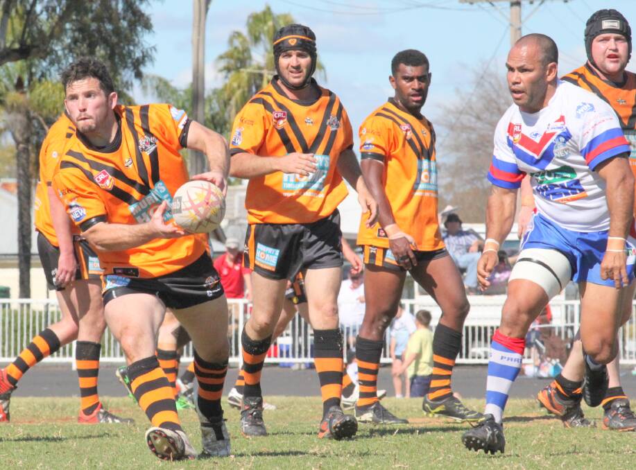 Nyngan s Luke Matheson in action while Dennis Moran, who was instrumental for Parkes, watches on. 
Photo: Stacey Wright