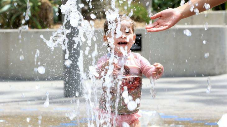 Anika, 2, plays in the water feature in Tumbalong Park, Darling Harbour. Photo: Kirk Gilmour