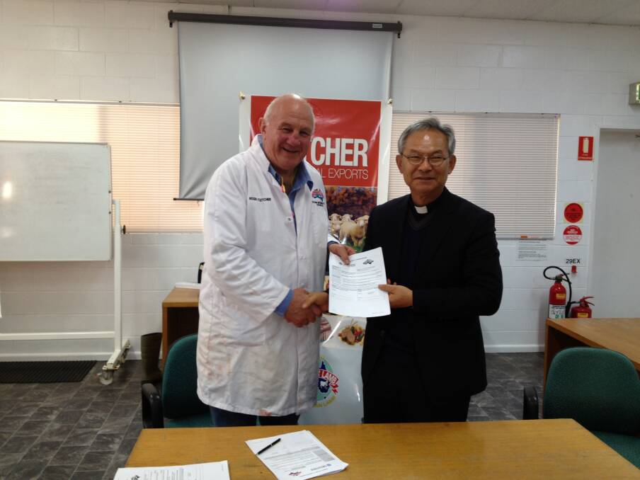 Roger Fletcher and Fr. Gabriel Chung, President of CSC holding their MOU. Photo: CONTRIBUTED