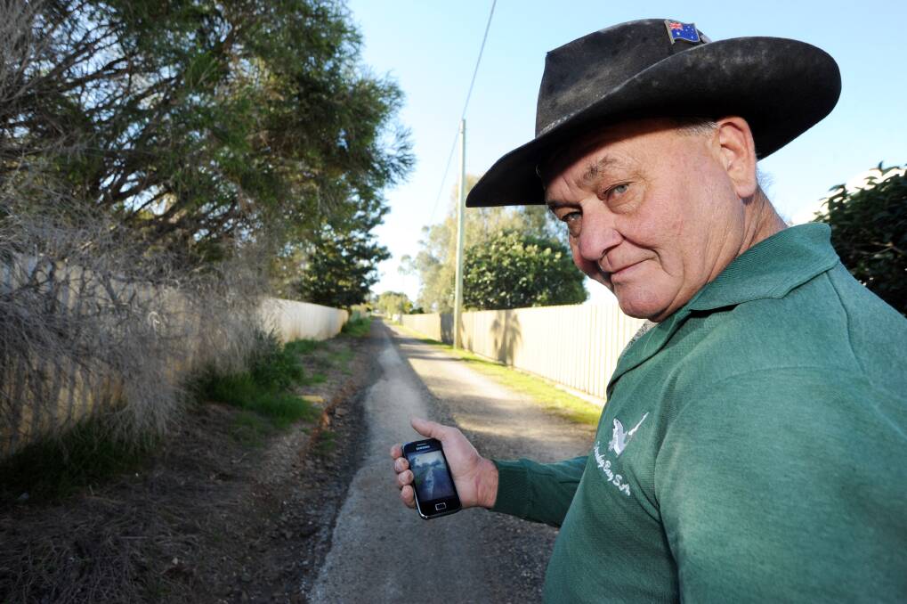 Brocklehurst resident Ken Piper with a photo taken on his mobile phone of water running down the lane after rain.       Photo: BELINDA SOOLE