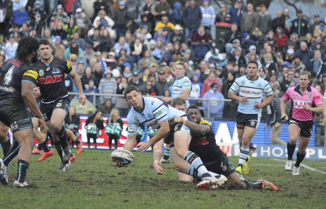 With a big crowd watching on, Cronulla s Jonathan Wright gets a pass away during his side s win over Penrith at Bathurst on Saturday. 	Photo: CHRIS SEABROOK