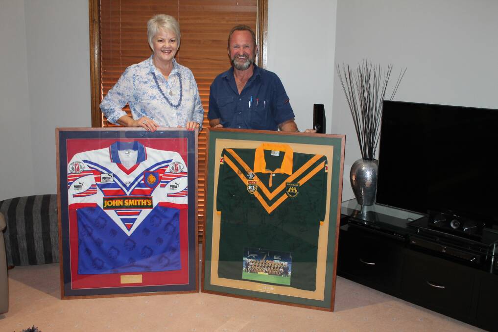 Gilgandra cancer fundraiser dinner organisers Wendy Nelson and Paul Morris with some of the memorabilia that will be up for grabs.  
Photo: THE GILGANDRA WEEKLY