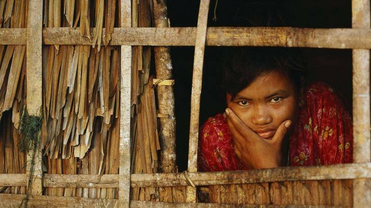 A Moken woman looks out from inside her home, Myanmar. Photo: Nicolas Reynard
