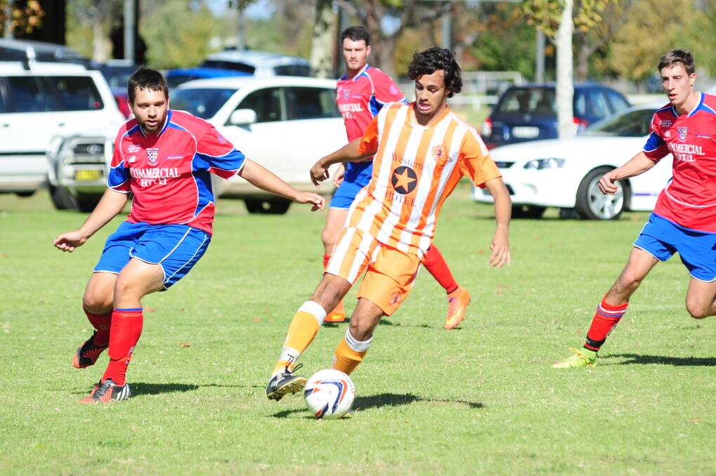 Dubbo FC's Alex Richardson shields the ball from Spurs opponents during Sunday's match.