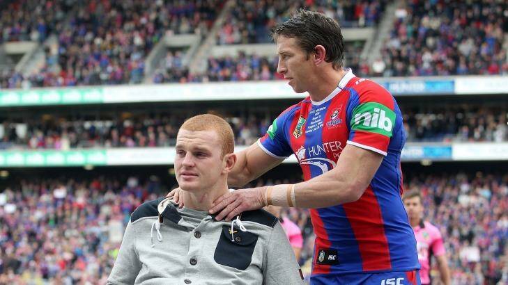 Kurt Gidley comforts Alex McKinnon before the start of the round 19 match between the Knights and theTitans. Photo: Tony Feder