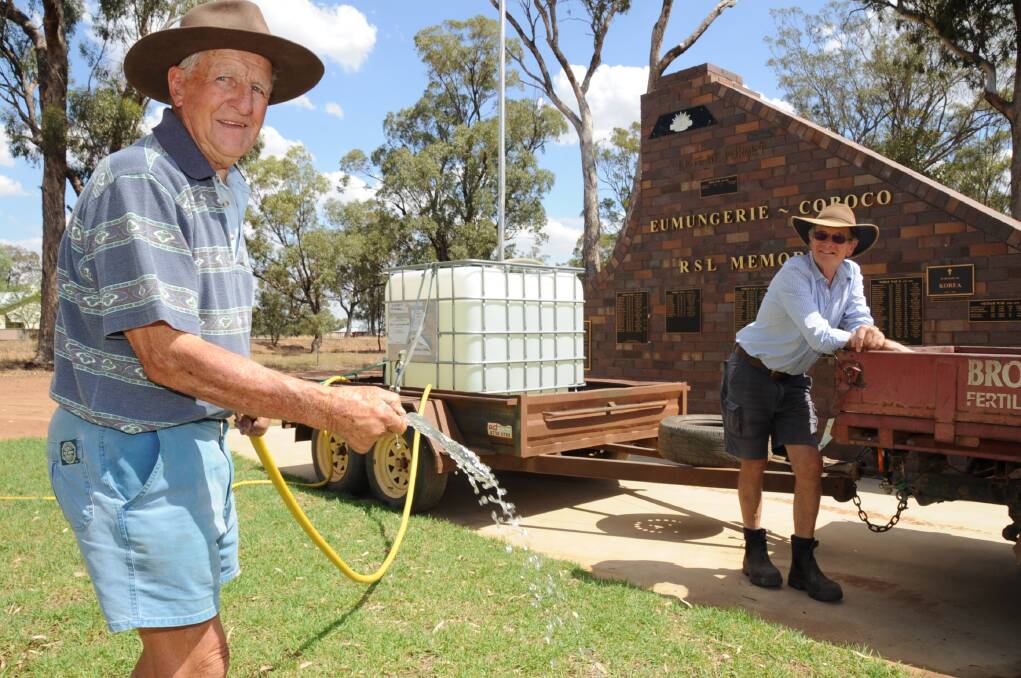 Eumungerie residents Les Brookfield and Leo de Kroo use their own water to care for the grounds of the Eumungerie cenotaph, carried by their vehicles. 									                   Photo: BELINDA SOOLE