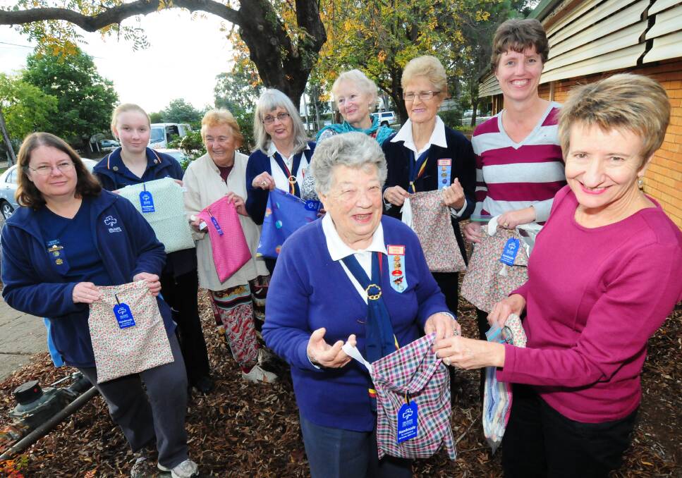 Wendy White, Laura White, Christine Cooper, Dorothy Olencewicz, Carolyn McCulloch, Norma Dunn and breast care nurse Vanessa Hyland watch on as Trefoil Guild member Pam Treloar presents breast care nurse Margie Collins with some of the bags.	 Photo: LOUISE DONGES
