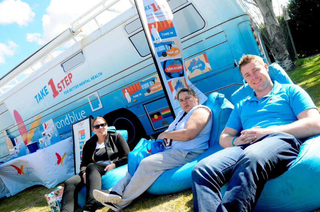 Joella Dwyer and Stacy Doolan enjoying the sunshine on the beanbags in front of the Big Blue Bus with Sam Walker events and volunteers manager at beyondblue.				  Photo: LOUISE DONGES.