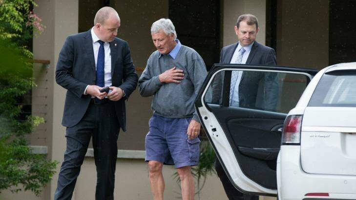 Bill Spedding, centre, is arrested in his Bonny Hills home by detectives on Wednesday.   Photo: Edwina Pickles