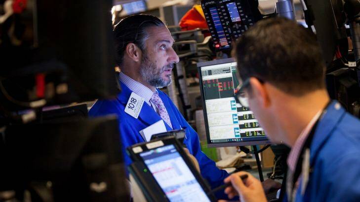 Traders on the floor of the New York Stock Exchange: Shares pared early losses after the deal frenzy set in. Photo: Michael Nagle