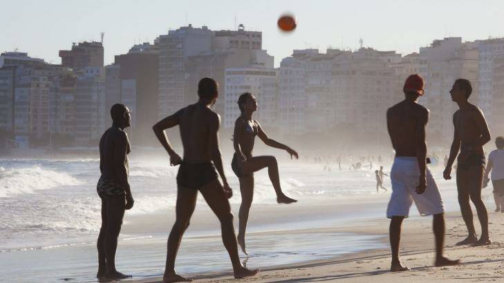 People of all ages play a hybrid of football and volleyball on Copacabana Beach. Photo: Peter Adams