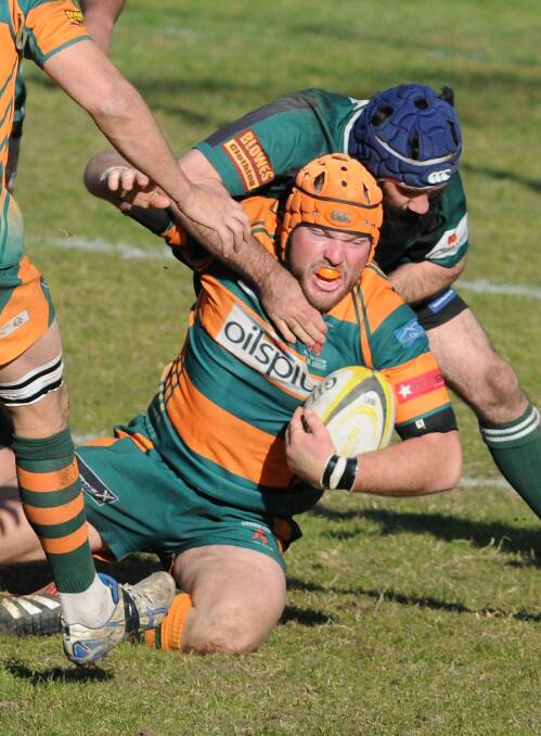 Orange City's Josh Tremain is tackled by Tom Goolagong last weekend. The Lions will be at Dubbo tomorrow looking to book a grand final spot. 	Photo: STEVE GOSCH