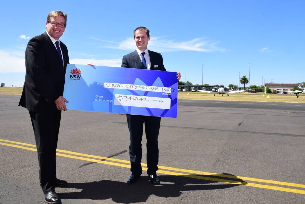 Mayor Mathew Dickerson receives a cheque for $7,460,421 from Member for Dubbo Troy Grant. The money will allow major improvements to be undertaken at Dubbo Regional Airport. Photo: BELINDA SOOLE