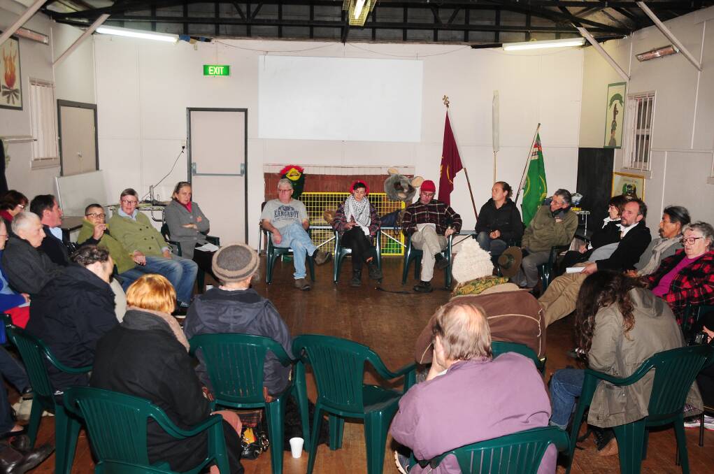 Alkane Resources' general manager NSW Mike Sutherland uses his hand to make a point at the Friends of the Earth meeting in Dubbo on Tuesday night. Listeners include Friends of the Earth's Dr Jim Green in the red beanie.					    Photo: Jackie Pratten