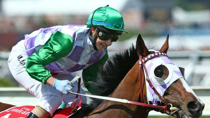Michelle Payne, riding Prince Of Penzance, smiles as she rounds the bend after winning the Melbourne Cup at Flemington on Tuesday. Photo: Scott Barbour