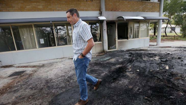Mr Shelton examines the damage to his office after a van with gas bottles exploded in the carpark. Photo: Andrew Meares
