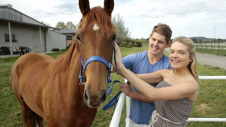 NSW batsman Daniel Hughes with his partner Erin Molan at Nick Olive's stables at Thoroughbred Park where their two-year-old filly is being trained. Photo: Jeffrey Chan