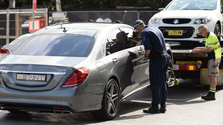 Police remove several luxury cars from an apartment building on Australia Avenue in Olympic Park. Photo: Wolter Peeters