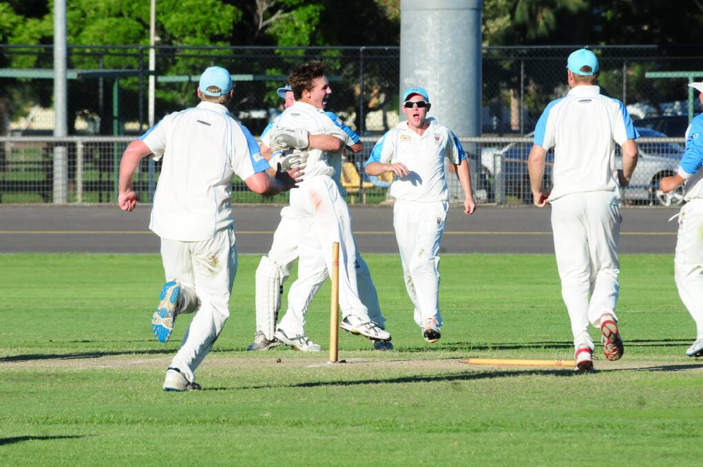 Rugby players rush in to celebrate with Ben Patterson after he bowled Tyler Cleary to seal the grand final victory.