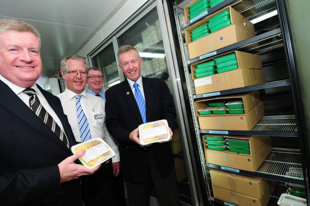 Assistant Minister for Social Services Mitch Fifield, Meals on Wheels Dubbo president Peter Carnell, Dubbo Meals on Wheels board member Ray Nolan and Parkes MP Mark Coulton inspect industrial freezers and meals at Meals on Wheels in Dubbo.                  Photo: LOUISE DONGES