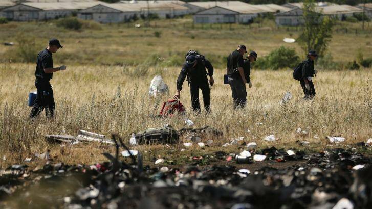 Compensation warning for families of MH17 victims: AFP officers search the crash site.  Photo: Kate Geraghty