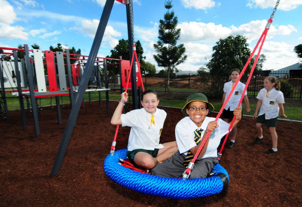 Dubbo North Public School students Temika Triplett and Bailey Ross enjoy playing on new equipment at Powter Park. Photo: LOUISE DONGES