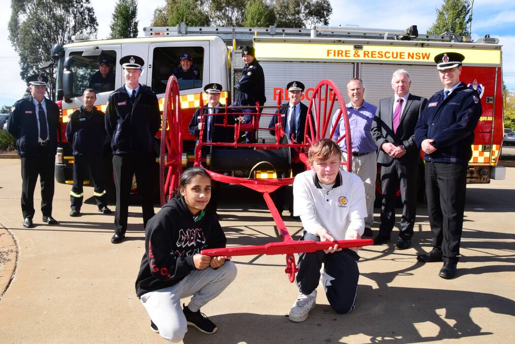 Dubbo College Senior Campus students Justine Gibson and Jessie Bonser with teacher Nigel White (third from right), campus principal Andrew Jones (second from right) and Fire and Rescue NSW staff (back row) Matt Havercroft, Tim Ryan, Steven Gilbert, (middle row) Steve Knight, Mick Medlin, Adam Wixx, Garry Barber, Neil Harris and Anthony Hojel. 						  Photo: BELINDA SOOLE