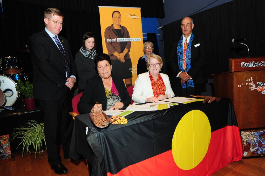 Aboriginal Community Reference Group chairwoman Anne Dennis and TAFE Western Institute director Kate Baxter sign a statement of intent as Dubbo MP Troy Grant and Aboriginal Reference Group members Ashleigh Knight, Jenny Robinson and Rod Towney watch on. 
Photo: BELINDA SOOLE