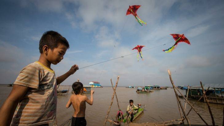 Children fly kites in the floating village. Photo: Jason South