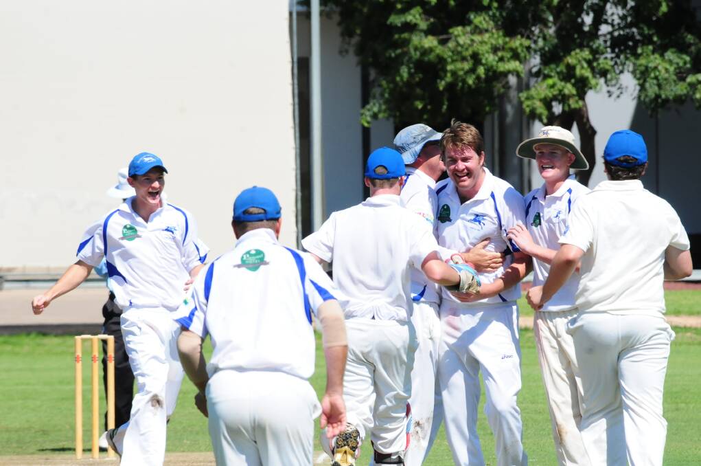 Macquarie players celebrate with Adam Thurlow after another wicket in their Pinnington Cup win.